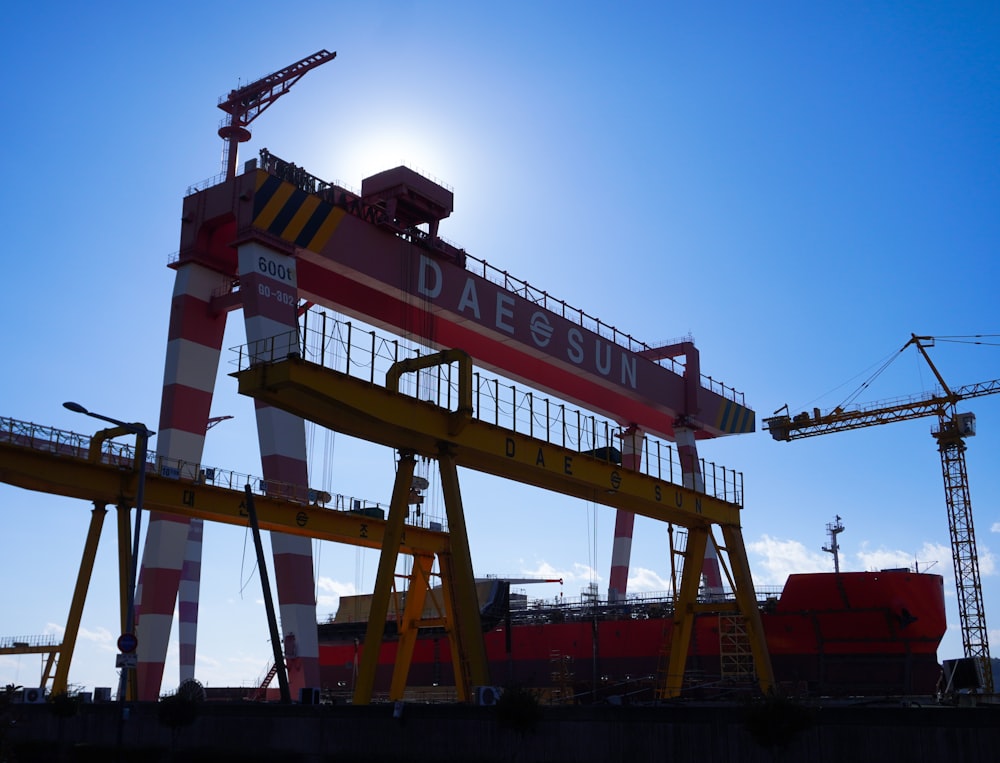 Une grande grue assise au sommet d’un pont sous un ciel bleu