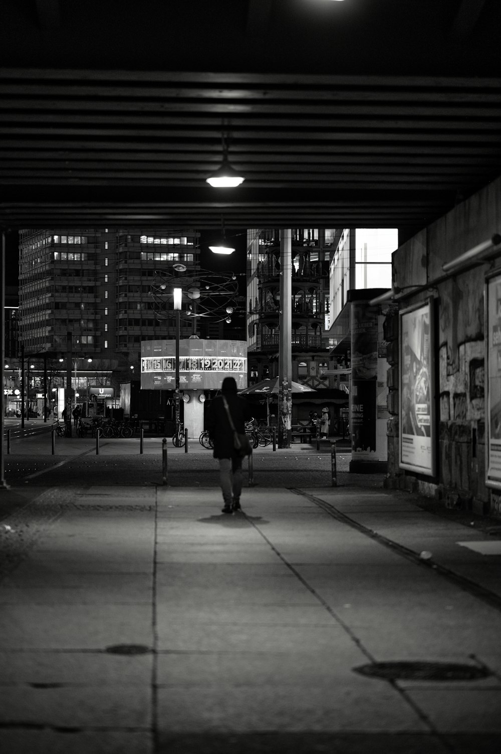 a person walking down a sidewalk at night
