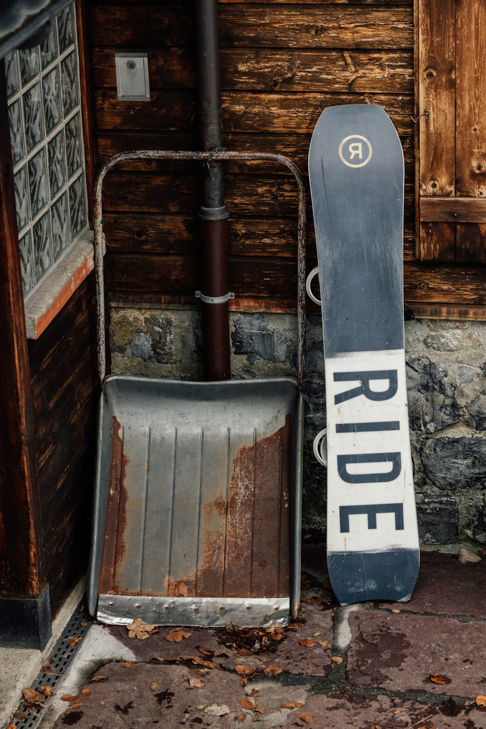a snowboard leaning against a building with the word ride on it