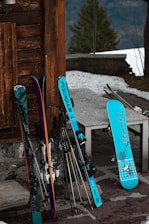 A set of freshly waxed skis resting against a wooden wall, ready for the slopes.