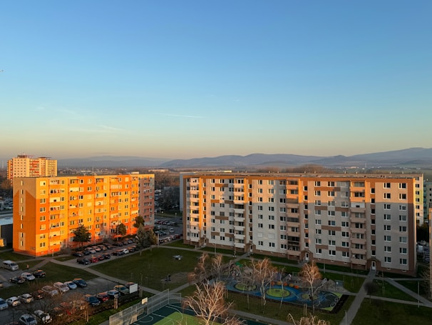 Finished apartment complex bathed in warm sunset light showing green landscaped areas.