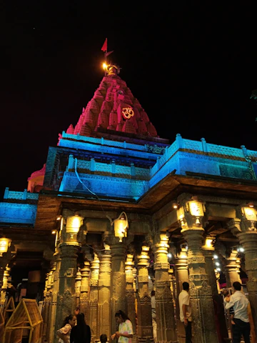Sunlit view of the Om Aashram temple with devotees gathered for morning prayers.