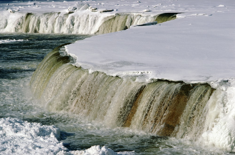 a frozen waterfall in the middle of a body of water