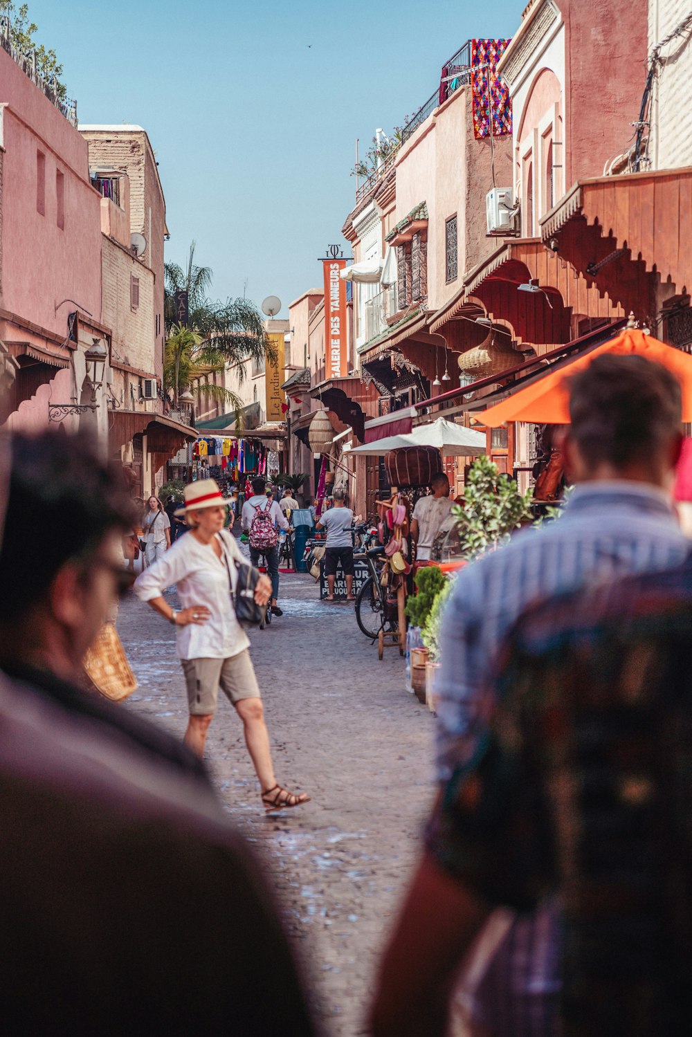 a group of people walking down a street next to tall buildings