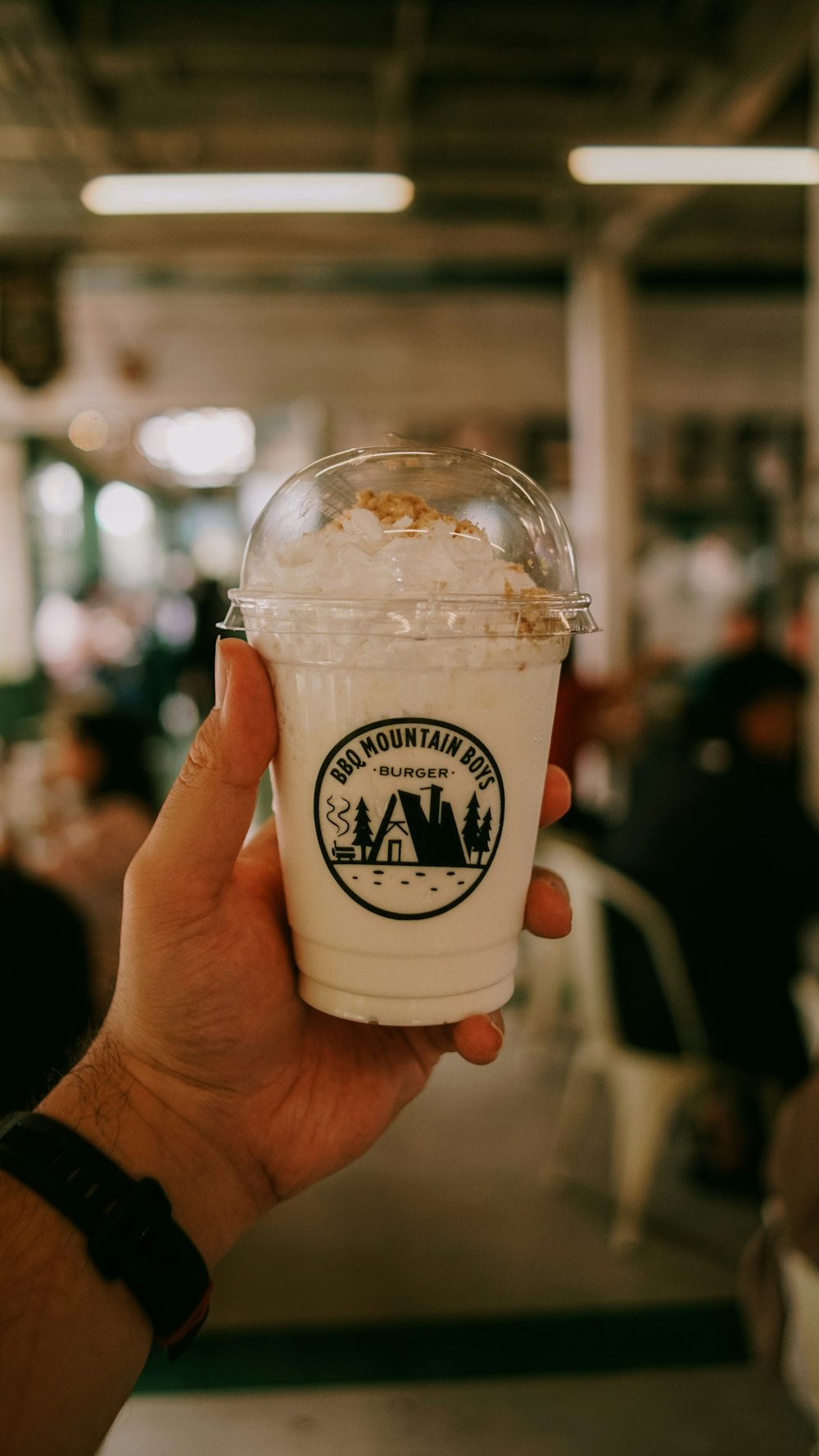 a person holding up a cup of ice cream