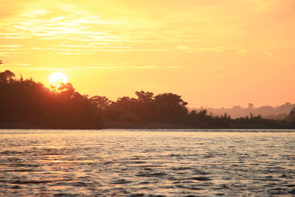 the sun is setting over a body of water