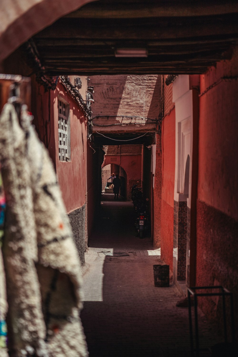 a narrow alley way with red walls and doors