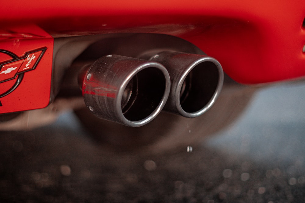 a close up of the exhaust pipes on a red sports car