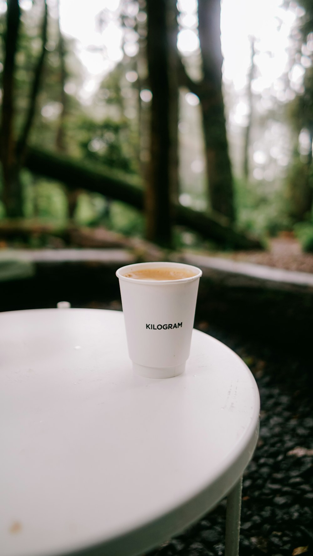 a cup of coffee sitting on top of a white table