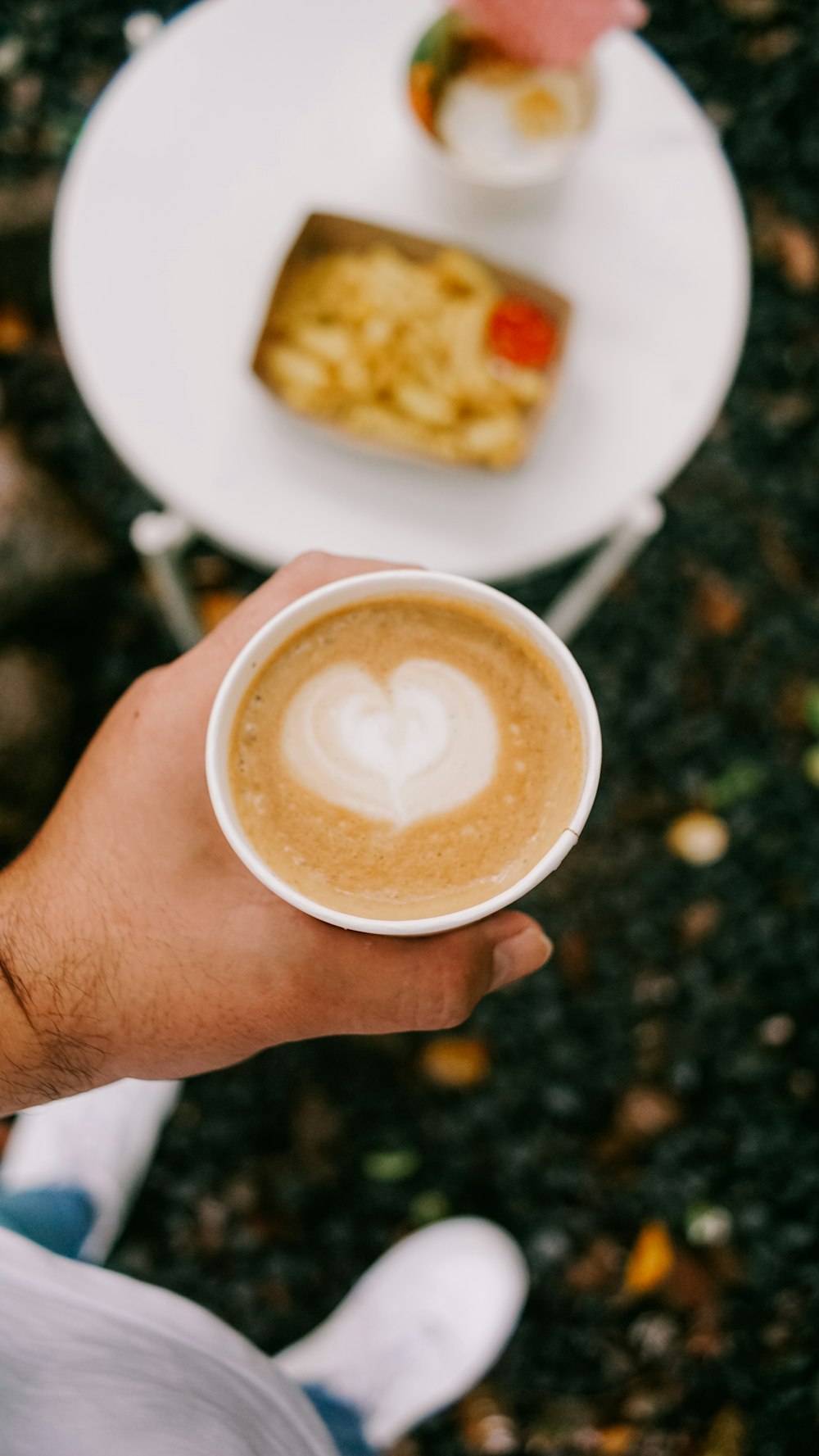 a person holding a cup of coffee in their hand