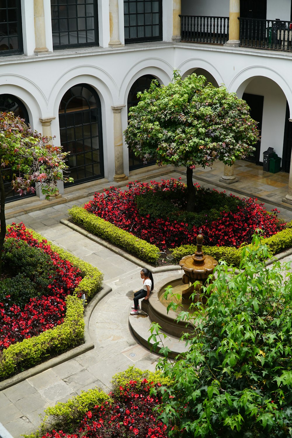 a person sitting on a bench in a courtyard