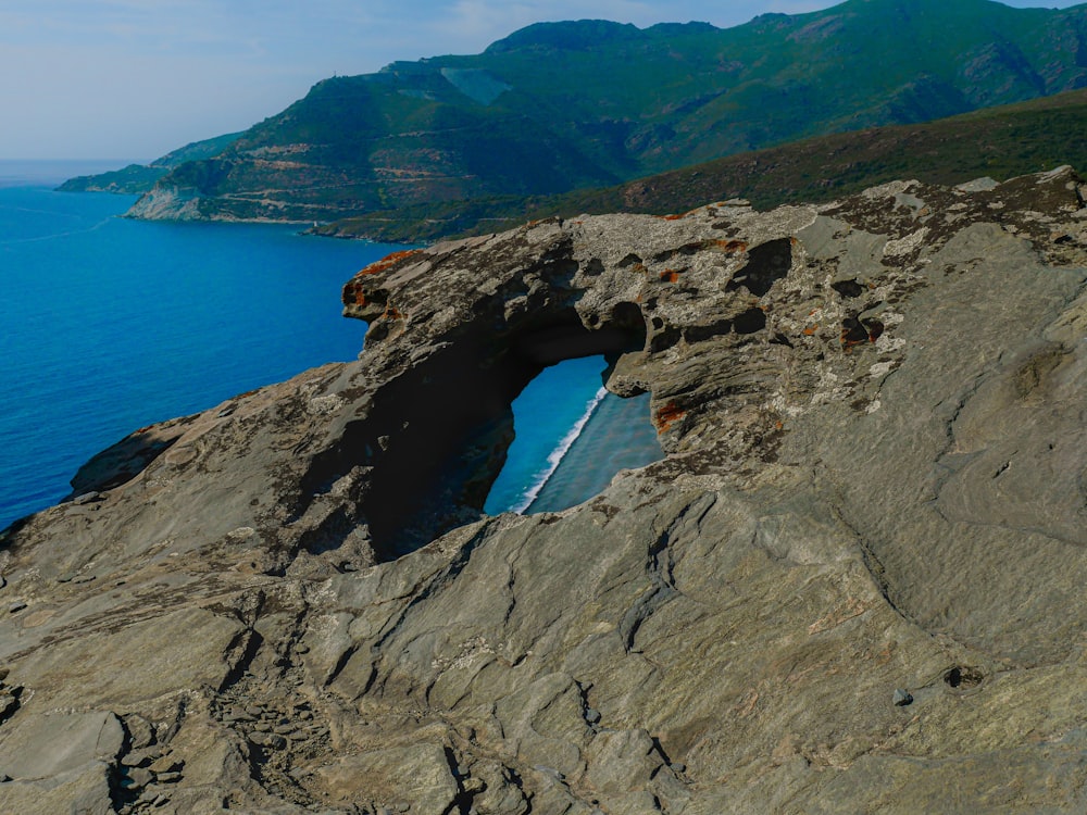 a rocky cliff with a hole in the middle of it