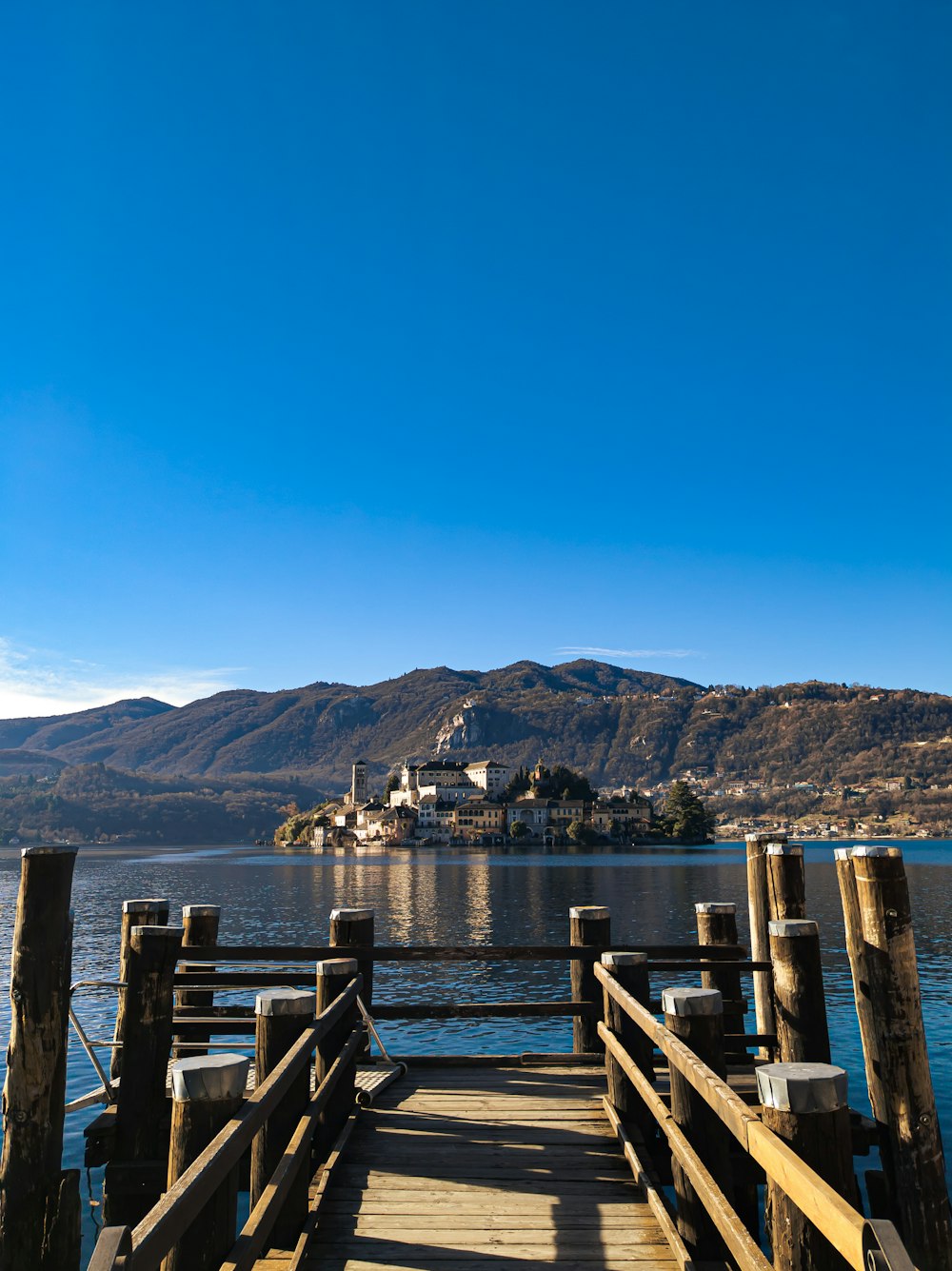 a wooden dock on a lake with mountains in the background