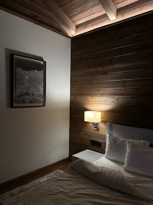 A cozy bedroom accent wall decorated with elegant 3D PVC panels in warm tones.