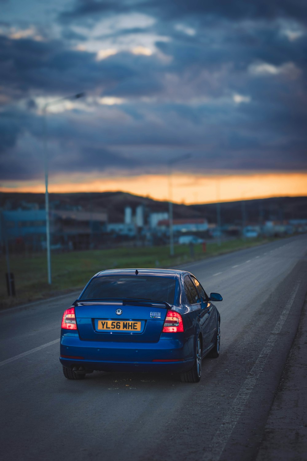 a blue car parked on the side of a road