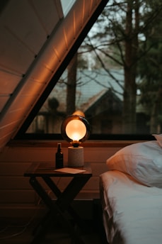 a bed sitting under a window next to a night stand