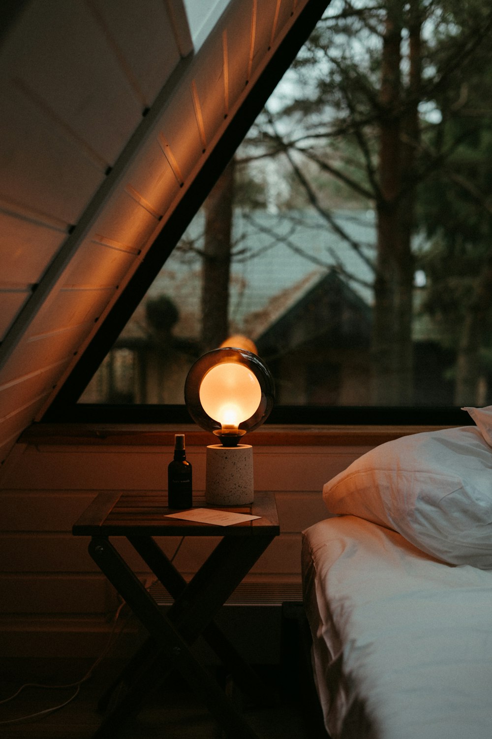 a bed sitting under a window next to a night stand