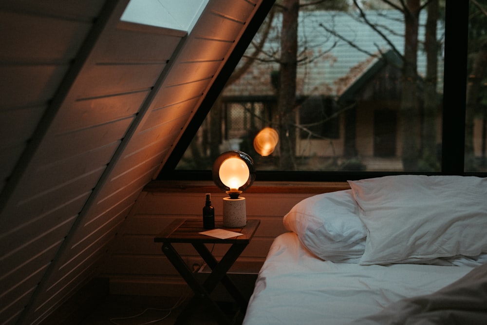a bed sitting under a window next to a night stand