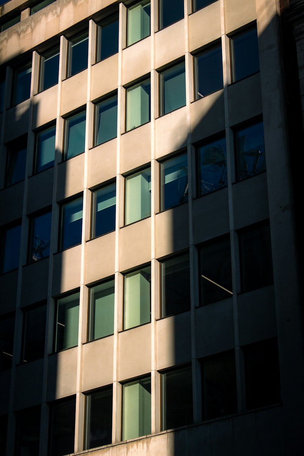 ein hohes Gebäude mit vielen Fenstern neben einer Straße