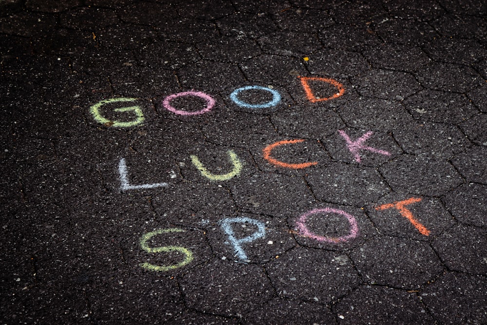 the words good luck and luck written in chalk on the pavement