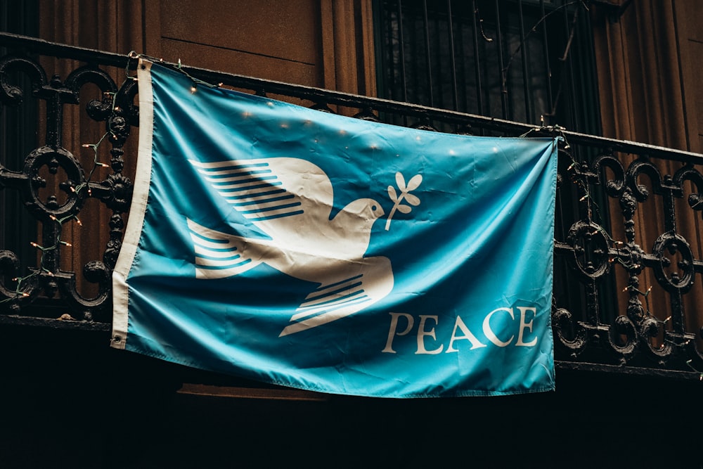 a blue flag with a dove and peace on it