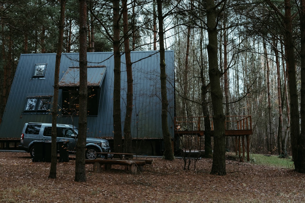 a truck parked in front of a house in the woods