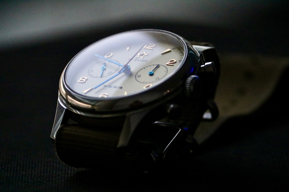 a close up of a watch on a black surface