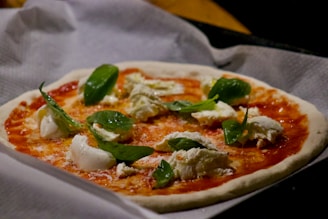 A delicious pizza topped with fresh basil and tomatoes.