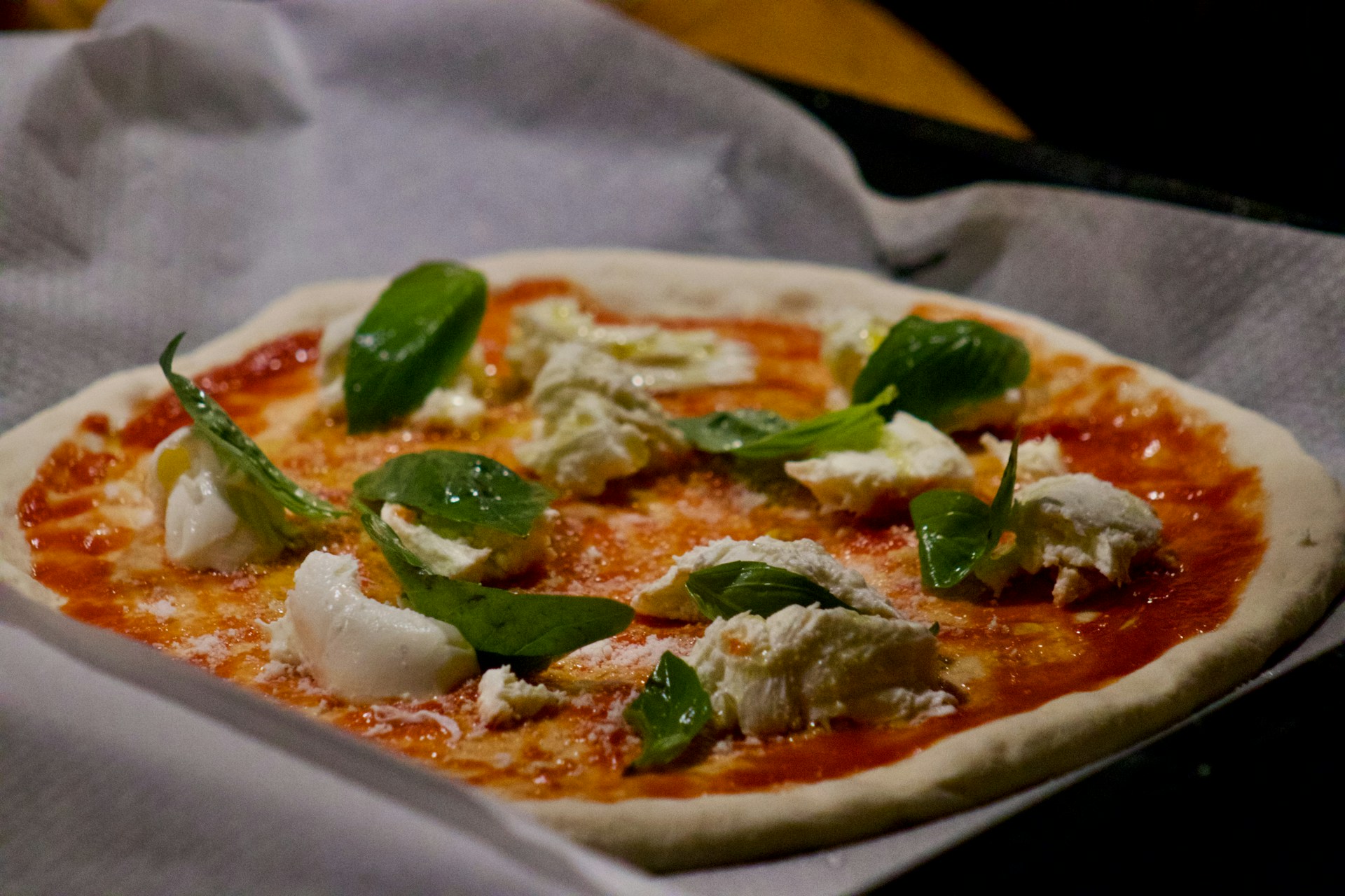 A beautifully arranged Italian pizza topped with fresh basil and mozzarella cheese.