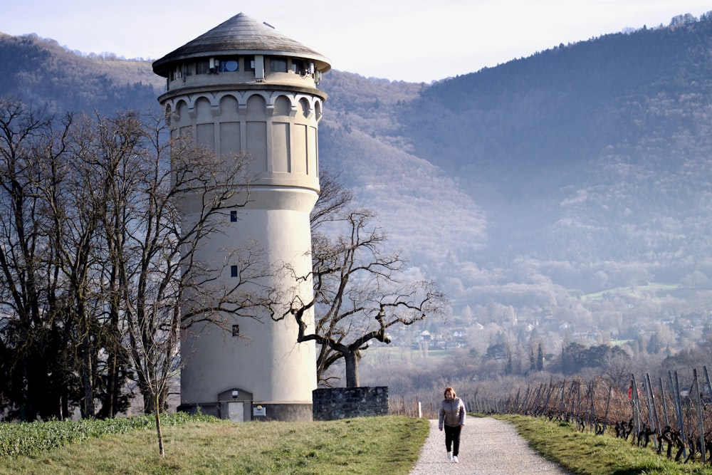 a person walking down a path towards a tall tower