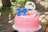 Festive birthday balloons and cake decorated with Oak City colors outdoors.
