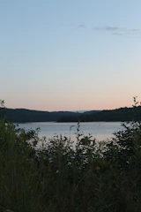 A serene view of Loch Lomond at sunset with Cameron House in the background.