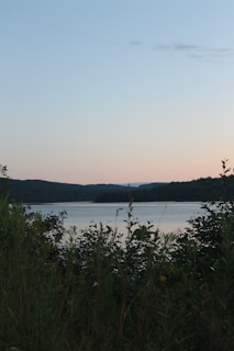 Sunset view over rolling hills and a peaceful lake.