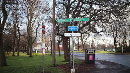 A close-up of a directional sign in a park.