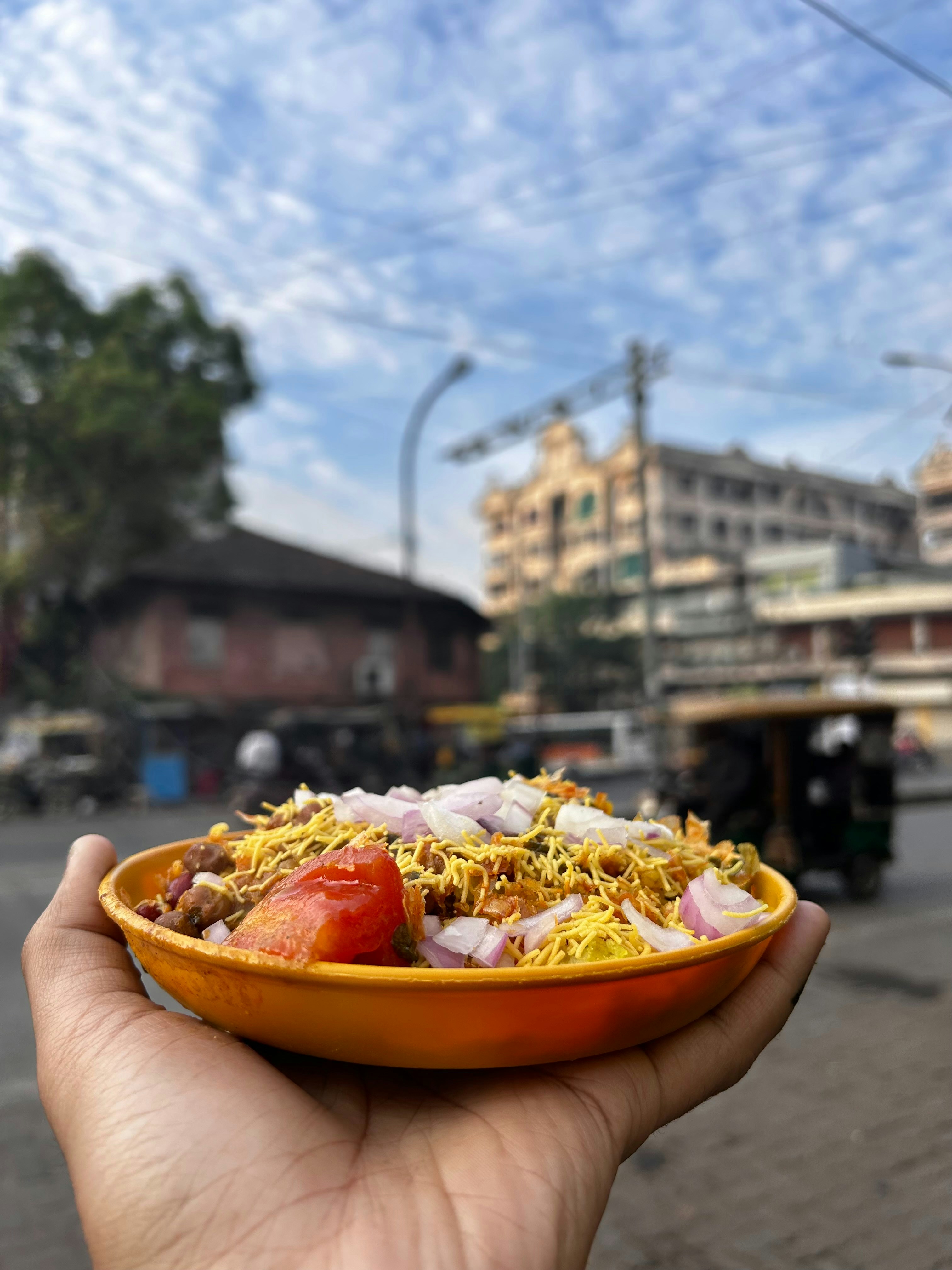 Close-up of steaming hot Indian street food in a bowl, dark atmospheric kitchen background, warm amber light