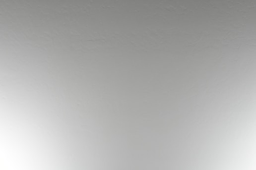 Close-up of a professional applying gypsum board to a ceiling with smooth finish.