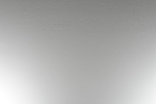 Close-up of a textured ceiling with elegant white paint and subtle lighting.