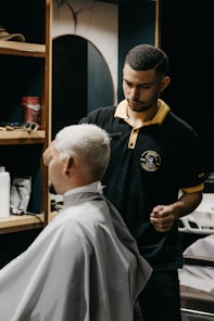 a man getting his hair cut by a barber