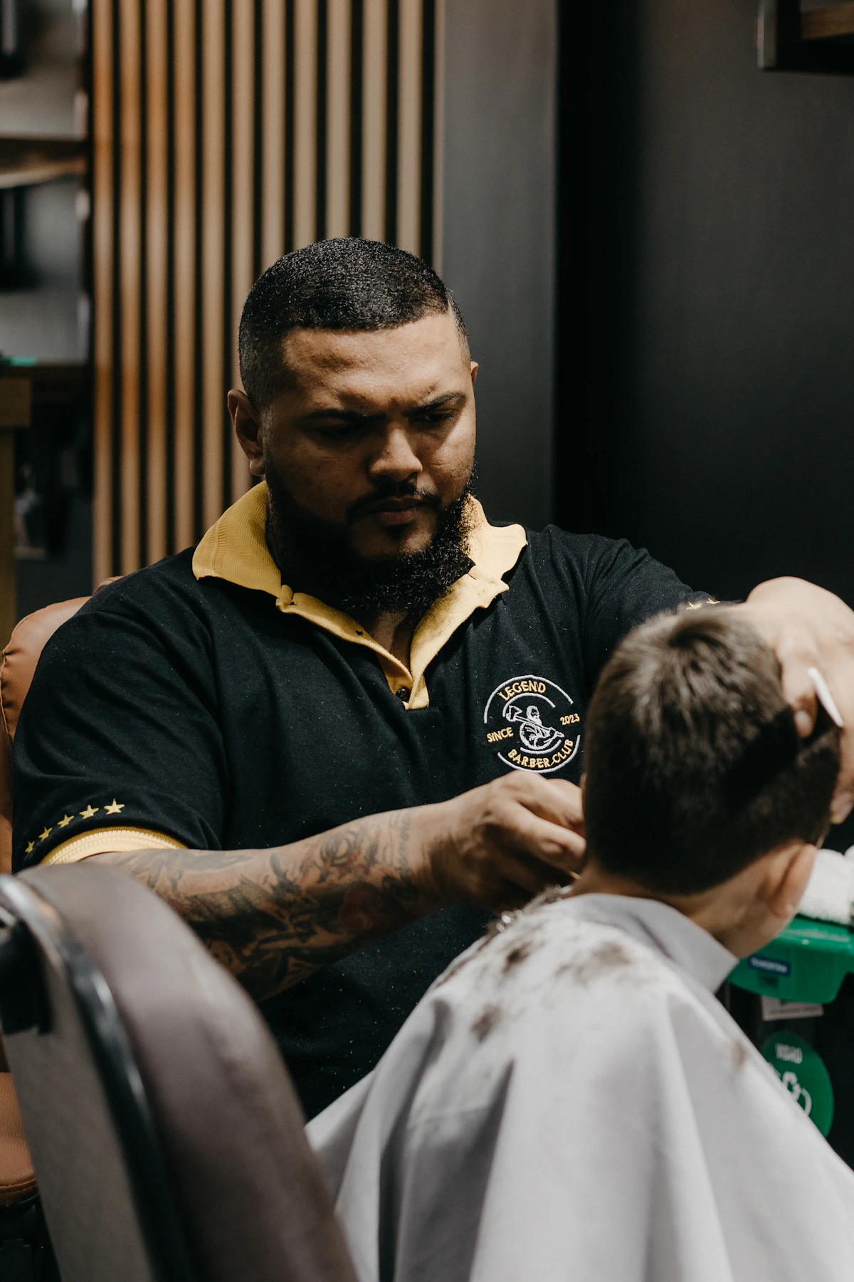 Barbeiro realizando acabamento em corte masculino