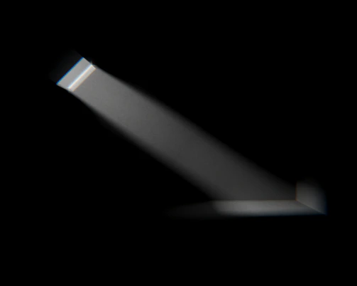 A striking 4K cinematic shot of a golden light beam cutting through a dark, smoky studio space.