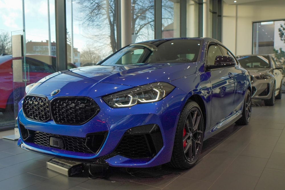 a blue car is parked in a showroom