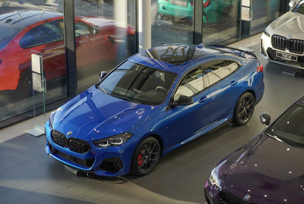 A satisfied customer shaking hands with a Velora sales consultant beside a polished BMW.