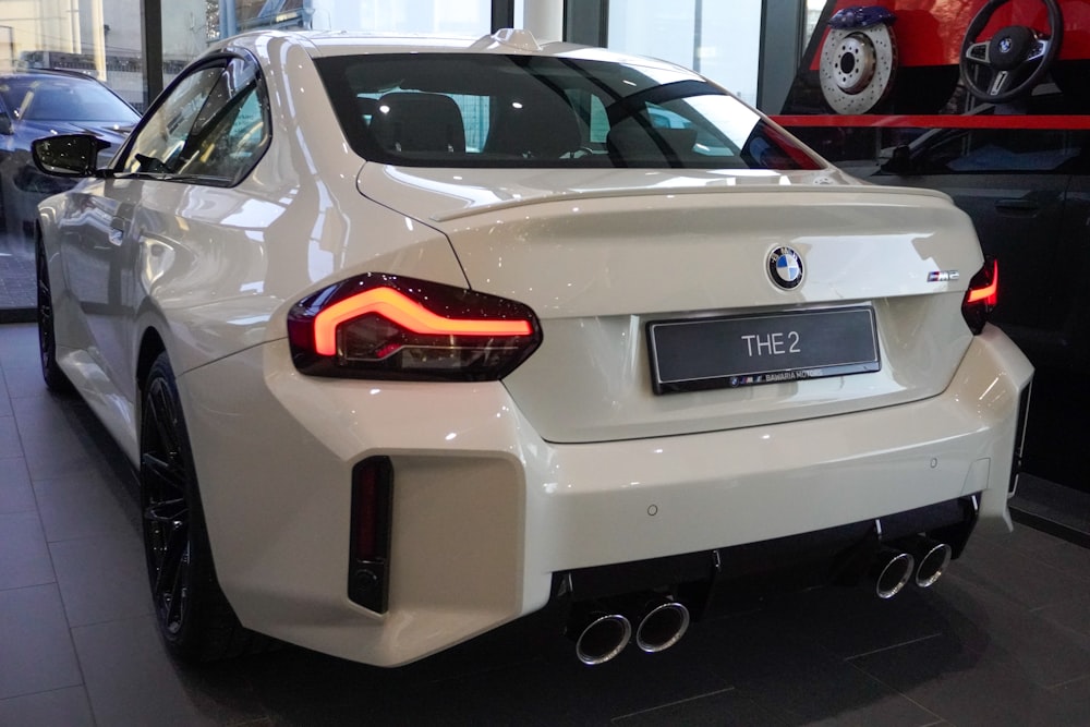 a white bmw car parked in a showroom