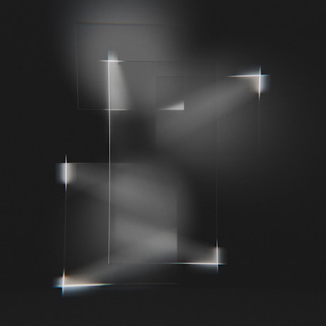 Abstract geometric shapes in slate blue and gold softly illuminated on a white surface.