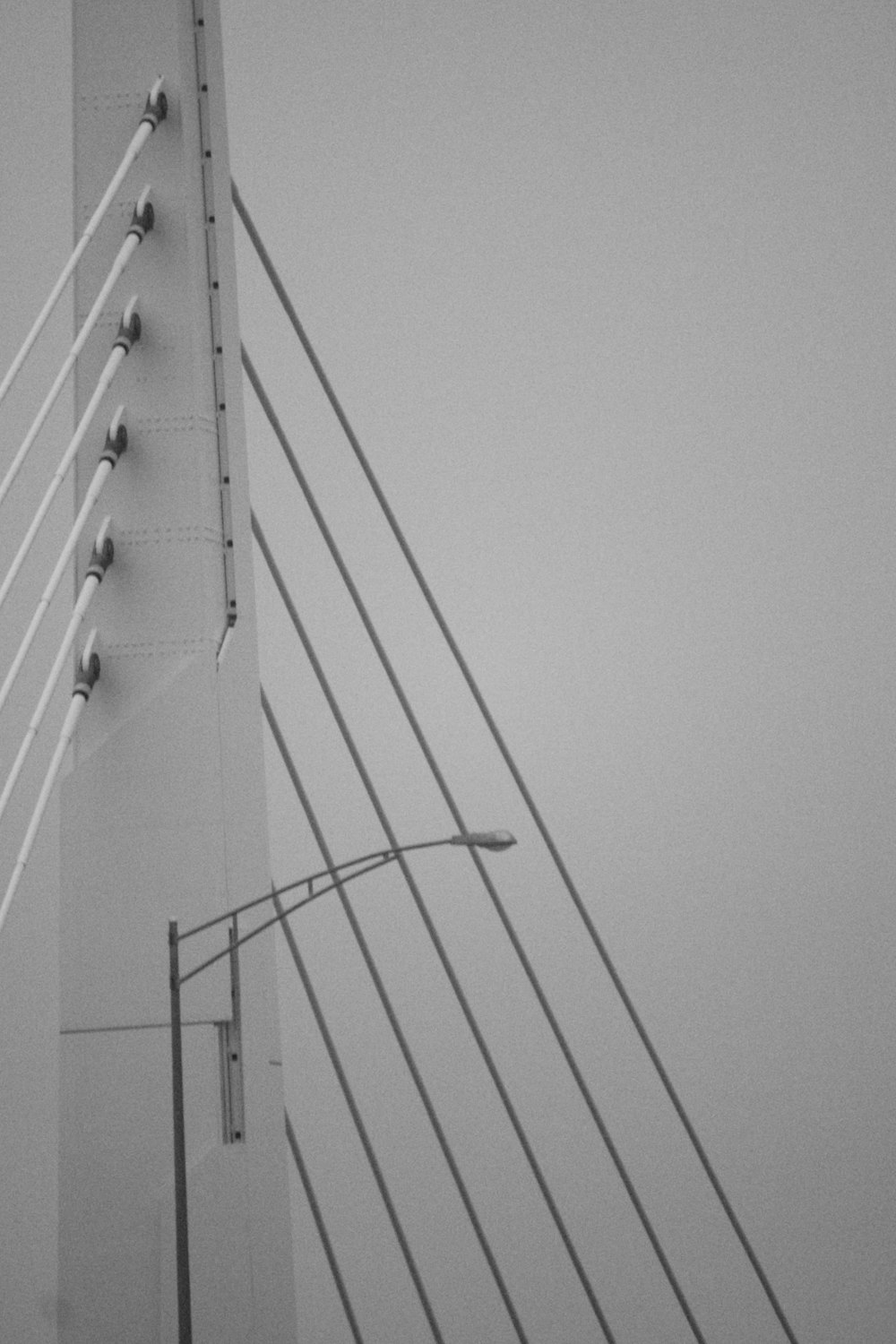 a black and white photo of a street light and a bridge