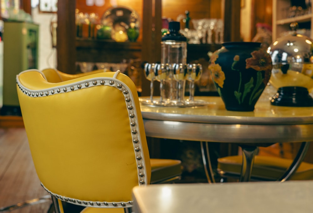 a yellow chair sitting in front of a table