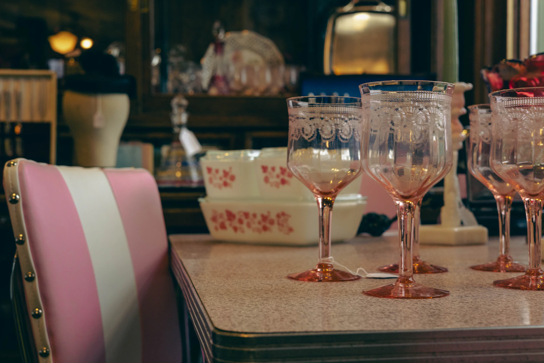 Pink lace-rim goblets with a price tag on a table in an antique shop