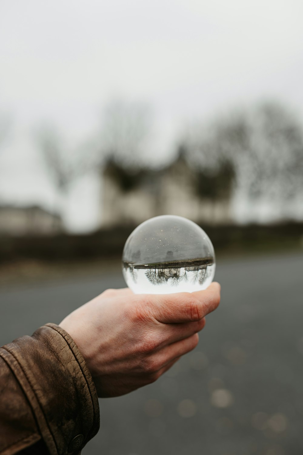 a person holding a glass ball in their hand