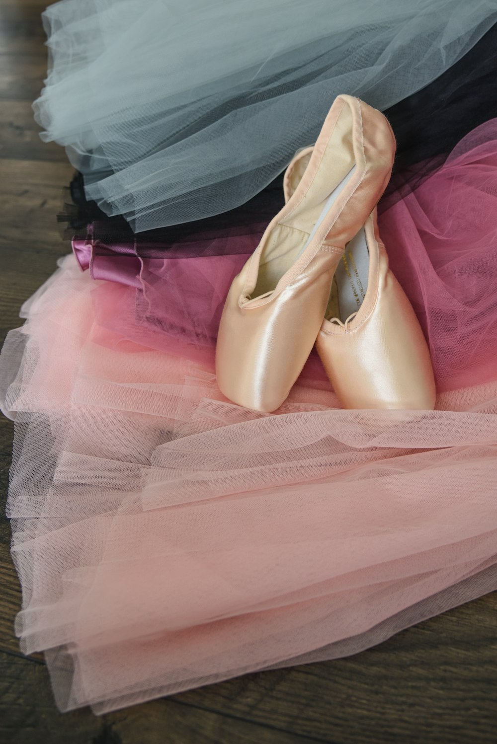 a pair of ballet shoes sitting on top of a pile of tulle