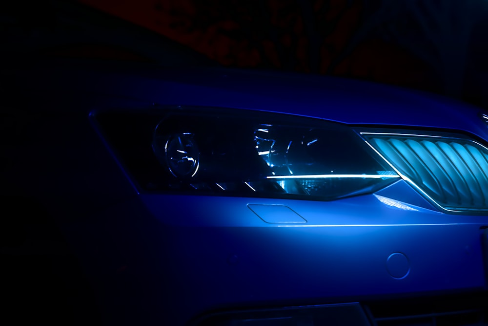 a close up of a blue car in the dark